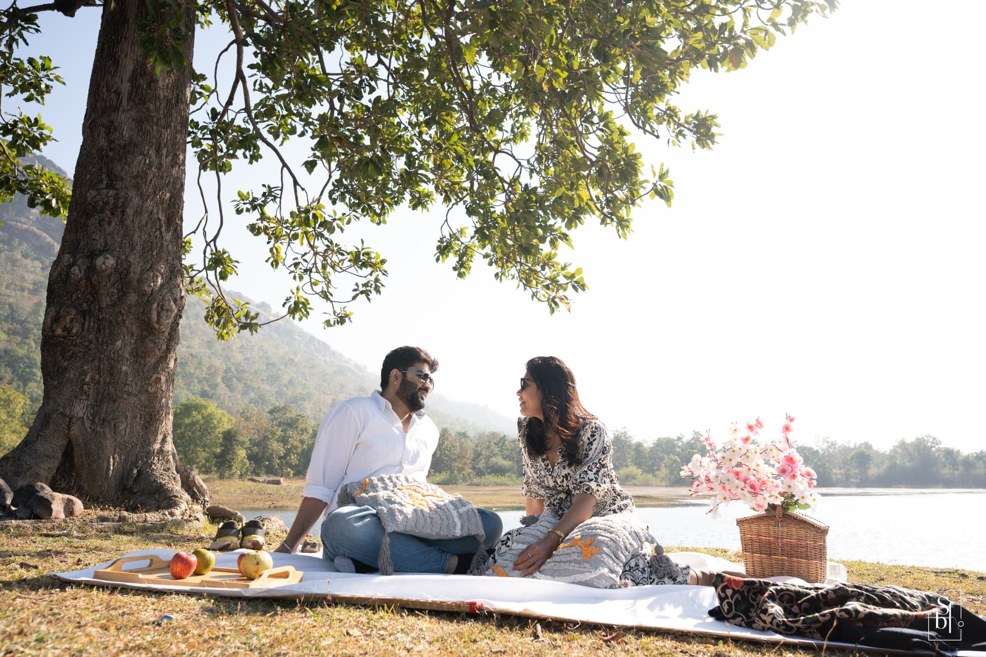 The couple sharing a lakeside picnic